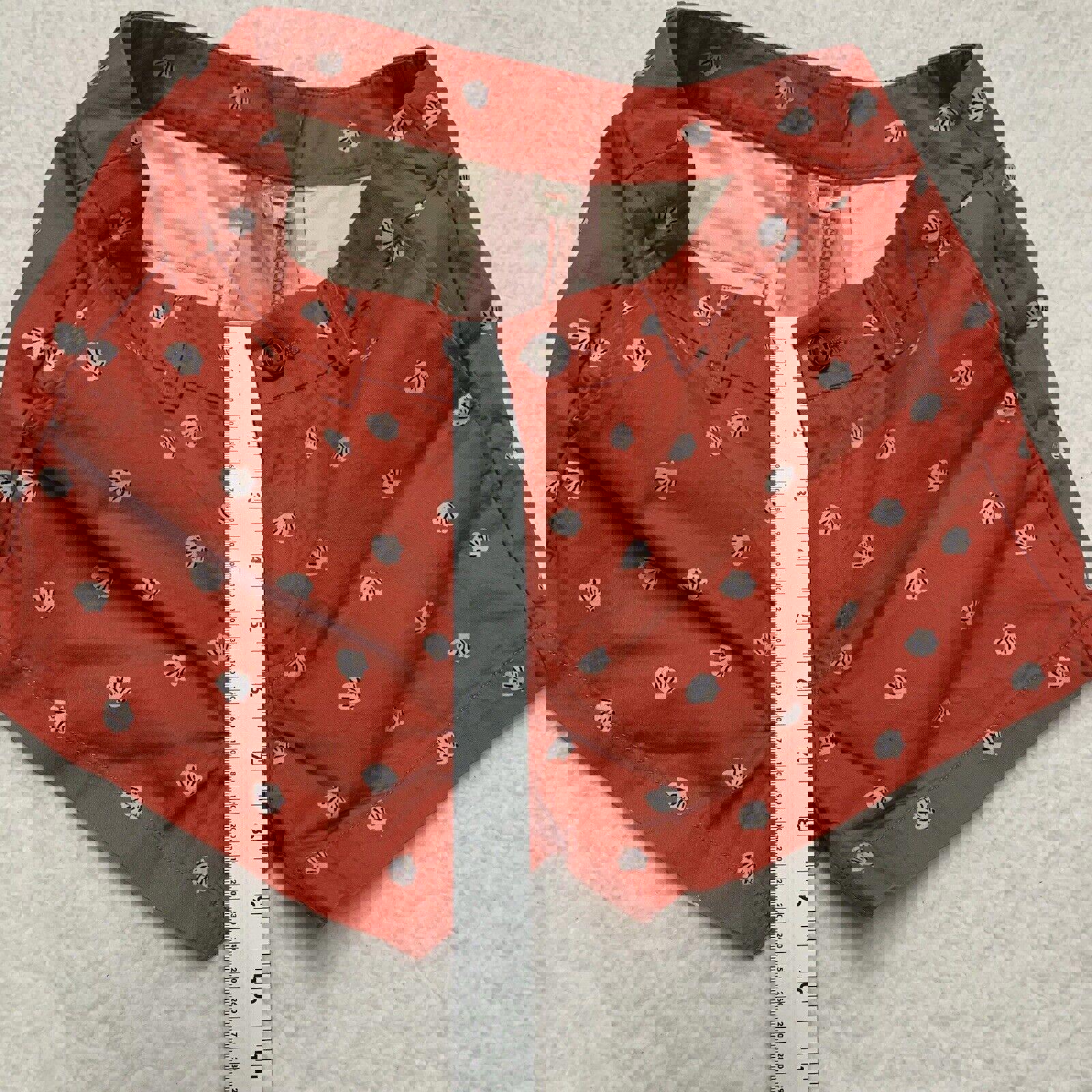 Pantalones cortos Uniqlo con estampado de conchas marinas, talla 2, parte delantera plana, color coral